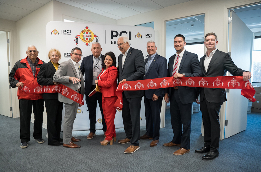 Chairwoman Stephanie Bryan (center, in red) joined tribal leaders and elders for a ribbon-cutting on a new office for PCI Federal. (Courtesy photo) 