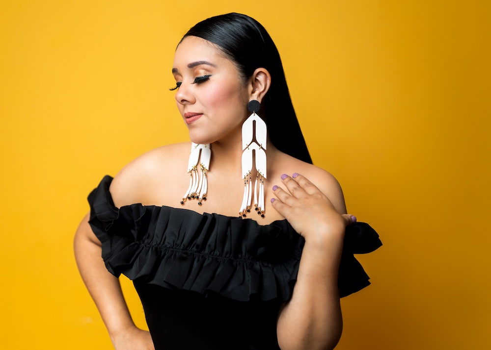 A model showcases large statement earrings that exemplify the "big extravagant pieces" aesthetic that McFadden strives for in her Isabella Rose Design Co. jewelry, designed to make a bold visual impact without weighing down the wearer. (Photo: Brenda Lozano)