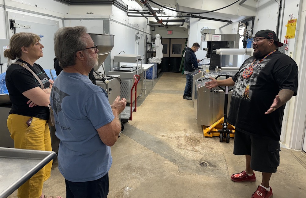 Chris White Eagle (right), founder of Sacred Storm Buffalo, discusses the workforce development and apprenticeship program with partners in the processing facility in Rapid City, S.D. The program trains young Lakota adults in buffalo processing while providing cultural reconnection and recovery support. (Photo: Courtesy of Sacred Storm Buffalo)