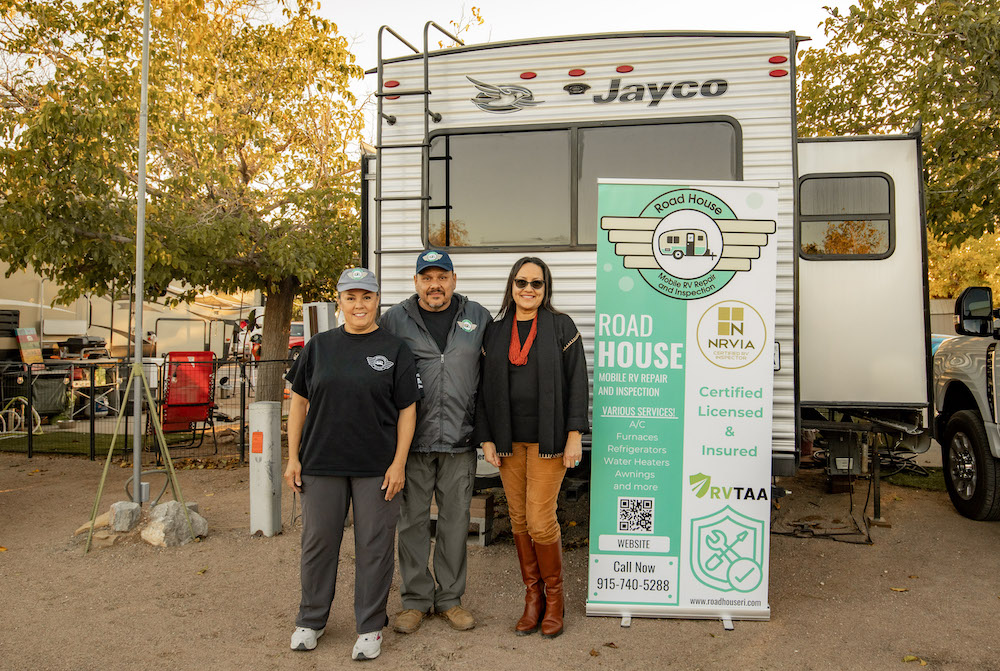 CAPTION 2 - (L-R) Owners Rosa and Rudy Serrano, owners of  Road House Mobile RV Repair, and Christine Serrano of the Tigua Community Development Corporation stand in front of a client's recreational vehicle and a service banner displaying their certifications and contact information. (PHOTO: Danielle Cortez)